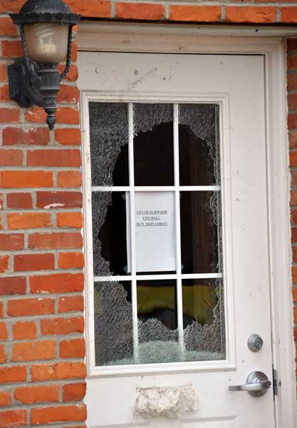 Front door of Elmwood's city hall, with broken glass surrounding the sign