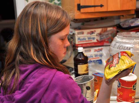 Cindy looks over a bag of chocolate chips for her cookies