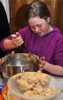 Cindy scoops cookie dough into a container