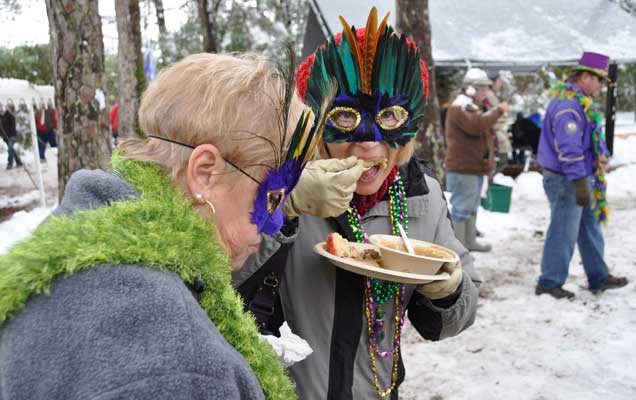 Two masked ladies caught in the unladylike act of eating gumbo