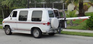 White van with 8 feet of aoluminum pipe sticking out the back