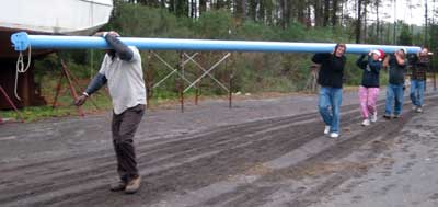 Bringing the masts home - Randy, John, Meps, Dick and Barry carry a carbon fiber spar on their inequal-height shoulders