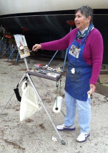 Artist working on her painting of a sailboat