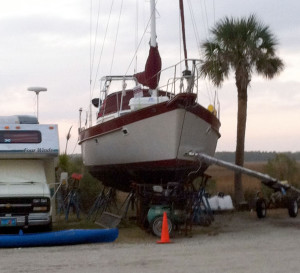 Average-looking fiberglass sailboat with lots of junk around it